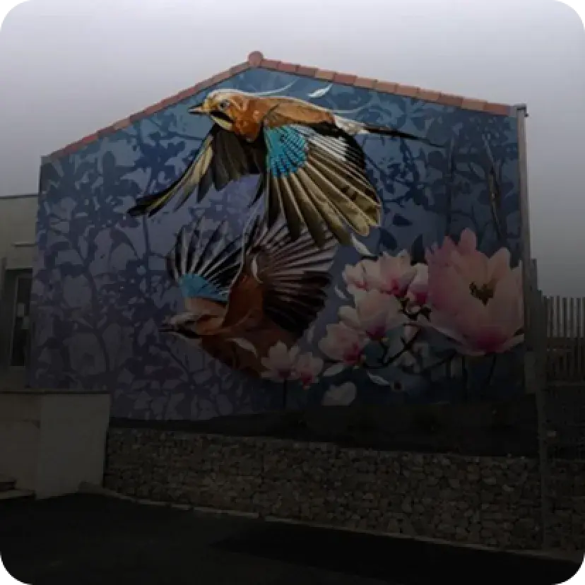 Mur d'un immeuble peint de deux oiseaux prenant leurs envole