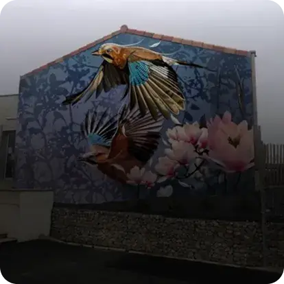 Mur d'un immeuble peint de deux oiseaux prenant leurs envole